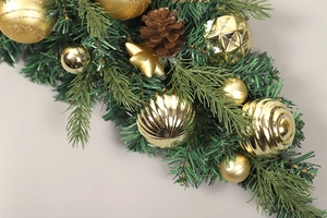 Detail eines Weihnachts-PVC-Umkehrbaums mit goldenen Ornamenten, Zapfen und Bändern