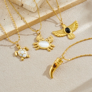 Gold stainless steel necklaces with turtle, crab, bird, and horn pendants on stone