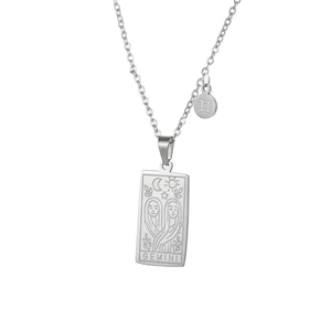 Macro shot of silver Gemini tarot pendant with stainless steel chain on white background