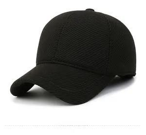 Detail view of thick black wool-like baseball cap fabric and side metal emblem