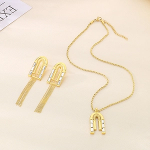 Golden luxury jewelry set with teardrop pendants and sparkling zircons on cream leather