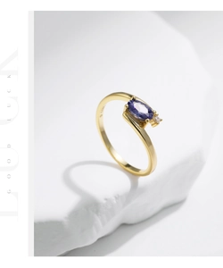 Detail of S925 silver gold-plated ring with oval purple gemstone and side zircon