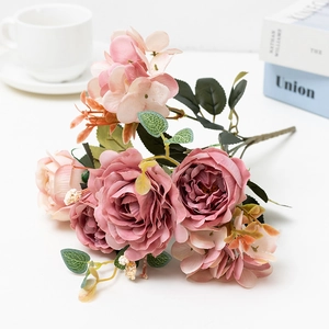 Close-up of pink artificial rose bouquet with hydrangea on a white desk setting