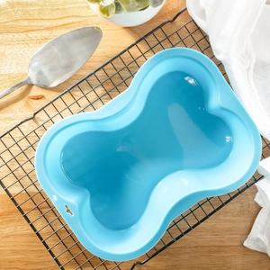 Blue silicone dog bone cake mold on cooling rack for creative DIY pet baking tools