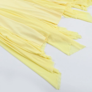 Détail de l'ourlet en maille jaune à plusieurs couches sur une robe ajustée à volants