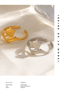 Detail of 18K gold and silver plated tulip flower rings on elegant silk background