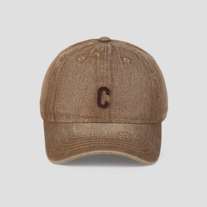 Close-up of the vintage brown washed denim fabric and embroidered letter C on the cap
