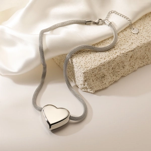 Silver 3D heart pendant necklace in stainless steel with mesh chain on marble