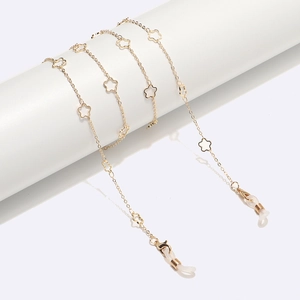 Golden hollow star metal eyewear chain with silicone loops shown on a display stand