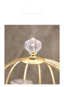 Detail of luxury gold metal rack featuring a clear faceted crystal pumpkin-shaped handle