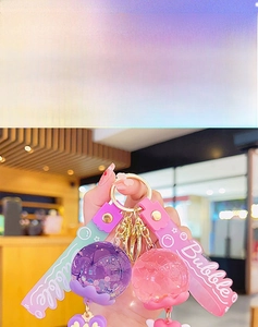 Detail niedlicher Bubble-Acryl-Schlüsselanhänger mit flüssigem Sand in Lila und Rosa