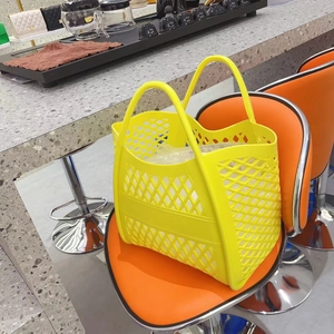 Detail of yellow perforated silicone tote bag on an orange chair in a shop
