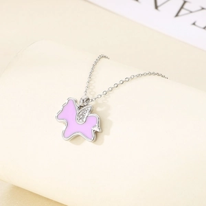 Detailed view of silver unicorn wing pendant with pink enamel and sparkling crystals