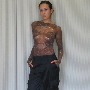 Détail d'un body transparent à manches longues avec strass brillants et maille filet