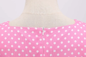 Detail view of pink polka dot dress showing back square neck and hidden zipper