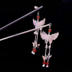 Exquisite silver butterfly tassel hair stick with red beads on a black background