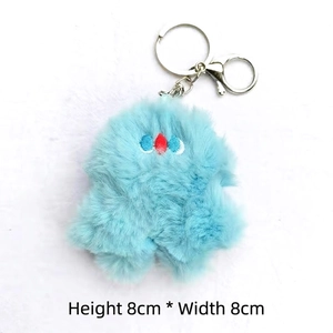 Close-up of blue plush monster keychain showing the 8cm compact size and metal lobster clasp