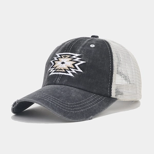 Detail of distressed brim and geometric embroidery on vintage mesh ponytail baseball cap