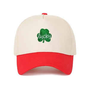 Close-up of green clover embroidery with lucky text on red and cream trucker hat