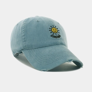 Close-up of sun embroidery and distressed brim on washed light blue baseball cap