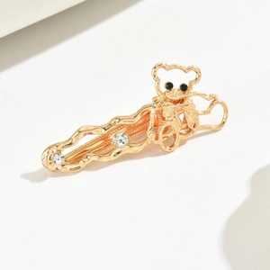 Golden alloy bear hair clip with bow detail and sparkling rhinestones on wavy band