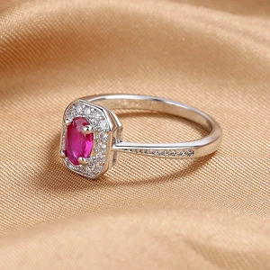 Macro shot of S925 silver ring featuring a red oval gemstone with zircon halo
