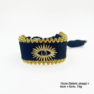 Detail eines gewebten Böser-Blick-Armbands mit Goldperlen, Quasten und 15 cm Stoffband