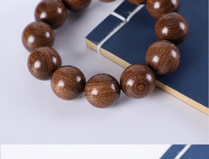 Macro view of natural grain on green sandalwood beads against a blue book background