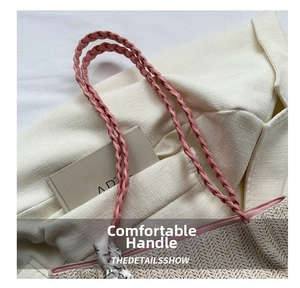 Gros plan du sac en paille beige avec anses tressées roses et foulard en soie décoratif