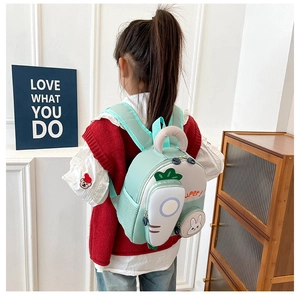 Detail view of a mint green cartoon backpack for kids featuring cute rabbit and carrot decor