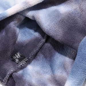Macro detail of cotton tie-dye beanie fabric showing looped texture and stitching