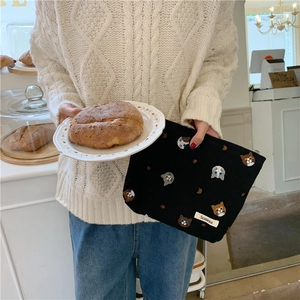 Close-up of black cotton linen cosmetic bag with cute embroidered cat heads and paws