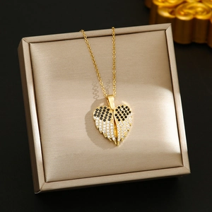 Detailed close-up of golden heart pendant with black and white pavé zircons