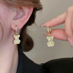 Détails de créoles dorées avec zircons et pendentifs oursons en résine irrisée