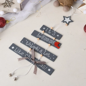 Detail of wooden Christmas tree hanging sign with bells and festive bird ornaments