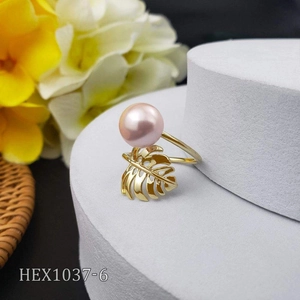 Macro shot of a golden monstera leaf ring featuring a polished pink natural pearl inlay