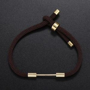 Detail of dark brown braided bracelet with adjustable gold slider and metallic bar