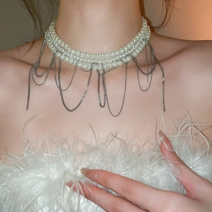 Détail d'un collier ras de cou en perles multicouches avec franges de chaînes argentées