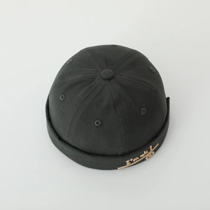 Close-up of black cotton docker hat featuring I'm ok embroidery and six-panel construction