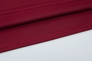 Macro view of double stitching detail on wine red dress hemline with clean finish