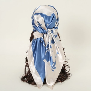Detail of silk satin scarf featuring abstract blue floral prints on a white background
