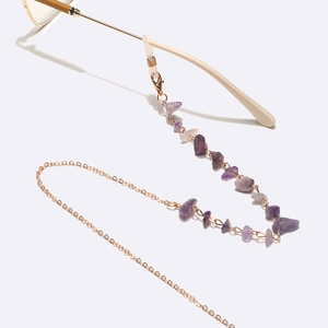 Detail view of gold metal eyewear chain with purple natural amethyst stones decoration