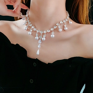 Elegant model wearing silver teardrop necklace with zircon crystals and a pearl pendant