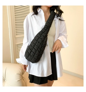 Détail d'un sac bandoulière noir matelassé avec bandoulière réglable sur un mannequin