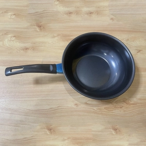 Top view of a black non-stick mini frying pan with an ergonomic handle on a wooden table