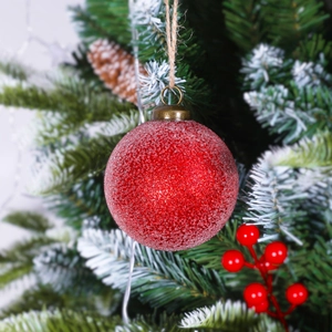 Close-up of red frosted Christmas ball with granular texture and jute hanging rope