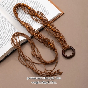 Detail view of woven bohemian belt with tassels placed on an open book for vintage style