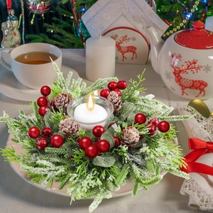 Couronne de bougie de Noël avec branches enneigées, baies rouges et photophore en verre