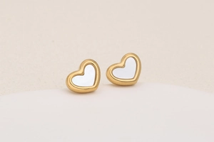 Detailed close-up of heart-shaped stud earrings in gold finish with white shell inlay