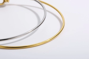 Macro detail of minimalist gold and silver adjustable stainless steel star moon bracelets